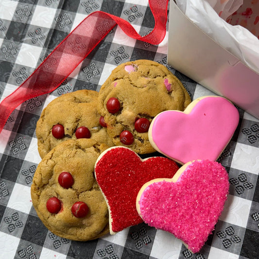 Heart-shaped cookies with red and pink hearts on a checkered tablecloth